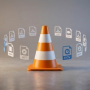 VLC Media Player's orange and white traffic cone icon centered on a gray surface, surrounded by a circular arrangement of media file format icons including MP4, AVI, MKV, MOV, and others